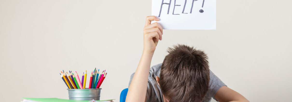 Resignierter Schüler mit Hilfe-Schild in der Hand
